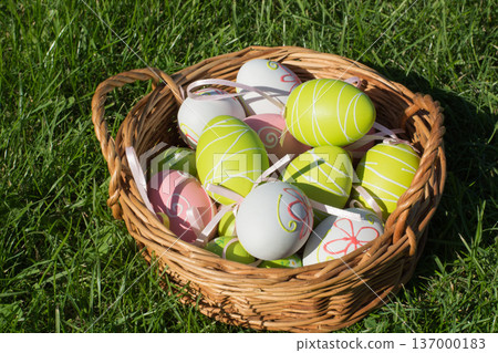Colorful Easter eggs in basket on grass, spring festive background Colorful Easter eggs in basket on grass, spring festive background 137000183