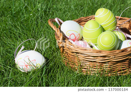 Colorful Easter eggs in basket on grass, spring festive background Colorful Easter eggs in basket on grass, spring festive background 137000184