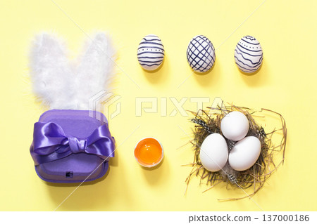 Creative easter composition with painted eggs, violet box and nest Creative easter composition with painted eggs, violet box and nest 137000186