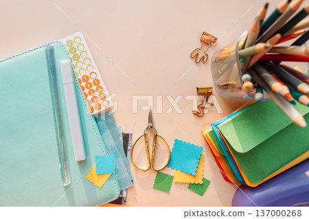 Crafting workspace with notebook, scissors, pencils and colorful paper pieces, journaling and scrapbooking concept Crafting workspace with notebook, scissors, pencils and colorful paper pieces, journaling and scrapbooking concept 137000268