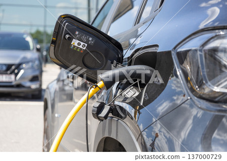 Electric vehicle charging at public station Electric vehicle charging at public station 137000729