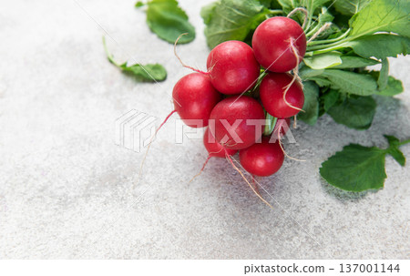 Fresh organic radishes with green leaves on light background Fresh organic radishes with green leaves on light background 137001144