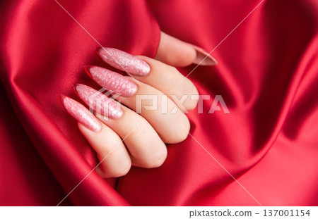 Female hand showing fashionable pink almond nails Female hand showing fashionable pink almond nails 137001154
