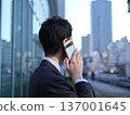 一位年輕的商人正在辦公區打電話 137001645