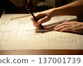 The hands of a Japanese architect drawing architectural drawings at night 137001739