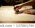 The hands of a Japanese architect drawing architectural drawings at night 137001740