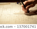 The hands of a Japanese architect drawing architectural drawings at night 137001741