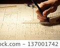 The hands of a Japanese architect drawing architectural drawings at night 137001742