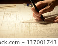 The hands of a Japanese architect drawing architectural drawings at night 137001743