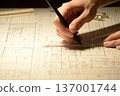 The hands of a Japanese architect drawing architectural drawings at night 137001744
