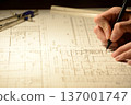 The hands of a Japanese architect drawing architectural drawings at night 137001747
