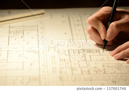 The hands of a Japanese architect drawing architectural drawings at night 137001748