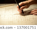 The hands of a Japanese architect drawing architectural drawings at night 137001751
