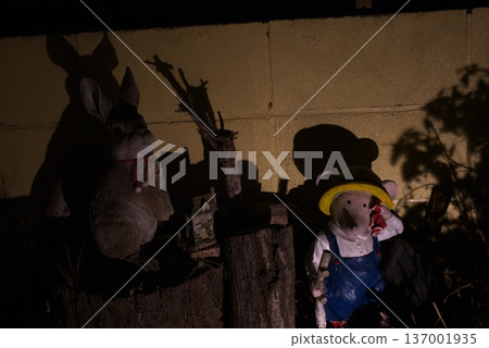 Rabbit and mouse garden objects lined up in a garden at night and their shadows cast on the wall Rabbit and mouse garden objects lined up in a garden at night and their shadows cast on the wall 137001935