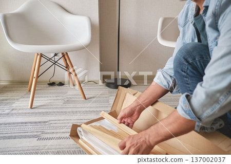 Handyman assembling furniture with instructions flat pack Handyman assembling furniture with instructions flat pack 137002037