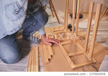 Handyman assembling wooden furniture for home improvement 137002056