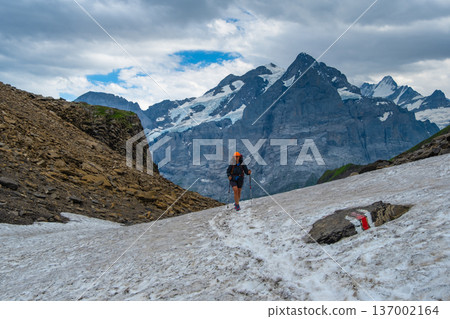 Sporty woman hiking in Switzerland alps. Heathy lifestyle, sport, beauty in nature. Grindelwald valley, Swizz Sporty woman hiking in Switzerland alps. Heathy lifestyle, sport, beauty in nature. Grindelwald valley, Swizz 137002164