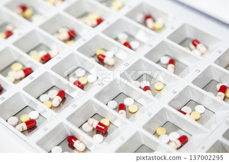 片劑和膠囊整齊地擺放在托盤上,準備包裝。 片劑和膠囊整齊地擺放在托盤上,準備包裝。 137002295