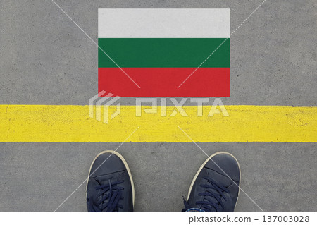 Start on an asphalt road with the Bulgarian flag and legs in shoes. Start on an asphalt road with the Bulgarian flag and legs in shoes. 137003028