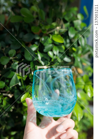 Hand-made blue glassware in hand in natural light 137003211