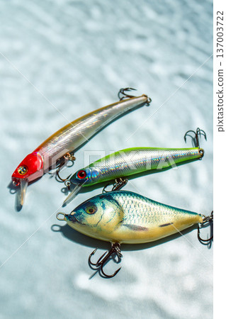 Flat lay of fishing equipment on blue background with water shadows. Close up of tackles and baits Flat lay of fishing equipment on blue background with water shadows. Close up of tackles and baits 137003722