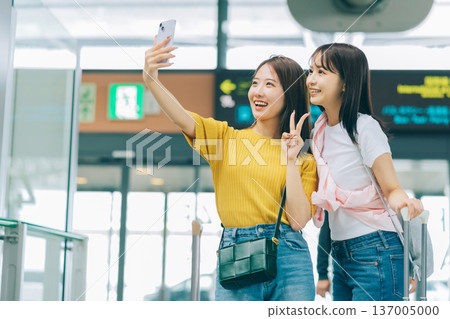 Two women taking a commemorative photo at the airport. (Photo courtesy of Kansai International Airport (KIX)) 137005000