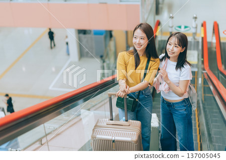 兩名女子正在機場搭乘自動扶梯。 （圖片由關西國際機場（KIX）提供） 137005045