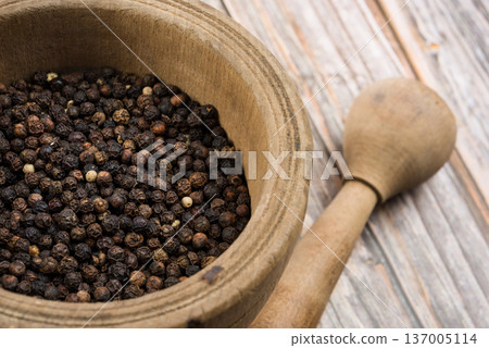 Black pepper corn into mortar and pestle 137005114