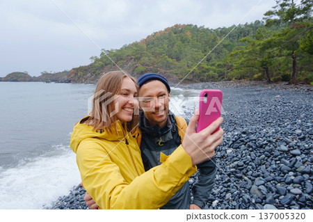 Couple taking selfie on beach in Winter 137005320