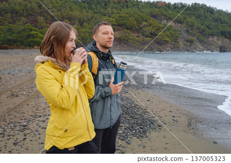 Couple drinks tea by winter sea shore 137005323