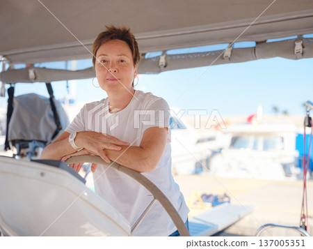 Woman Captain Steering Yacht Wheel Maneuvering From Marina 137005351