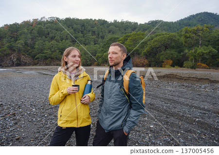 Couple drinks tea by winter sea shore Couple drinks tea by winter sea shore 137005456