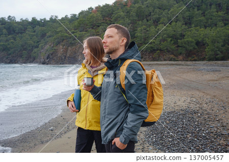 Couple drinks tea by winter sea shore Couple drinks tea by winter sea shore 137005457