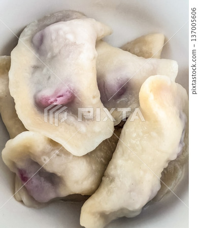 Delicious homemade pierogi, traditional Polish dumplings with a sweet berry fruit filling, served in a white bowl. 137005606