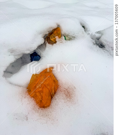 Colorful plastic garbage, bags and bottles, polluting the fresh white snow in winter. Environmental conservation concept. Colorful plastic garbage, bags and bottles, polluting the fresh white snow in winter. Environmental conservation concept. 137005609