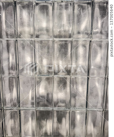 Textured glass block wall. Abstract architectural background with light reflections and distortion. Textured glass block wall. Abstract architectural background with light reflections and distortion. 137005640