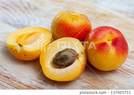 Image of ripe juicy apricots on wooden table in kitchen 137005751