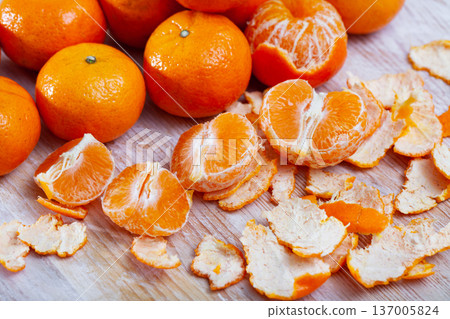 Ripe peeled tangerines on wooden table in kitchen Ripe peeled tangerines on wooden table in kitchen 137005824