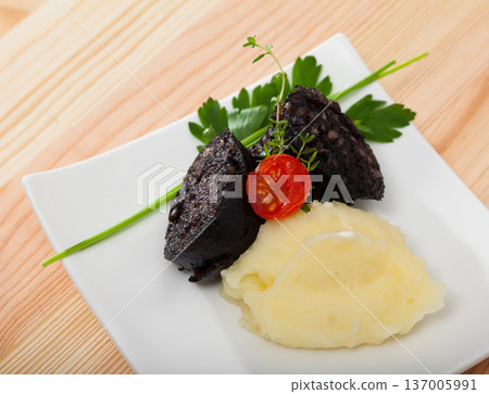 Blood sausage with mashed potato served at plate with greens Blood sausage with mashed potato served at plate with greens 137005991