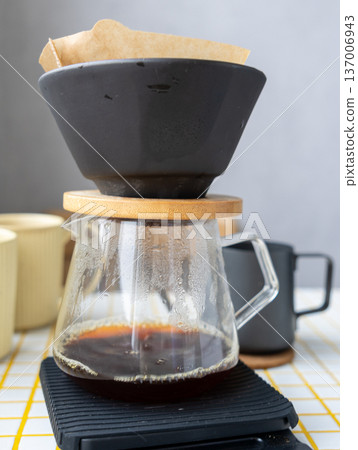 coffee made from coffee beans. person makes coffee through a paper filter, pour over or drip.  137006943