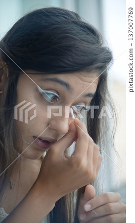 Precise application of white eyeliner on eye in soft lighting Precise application of white eyeliner on eye in soft lighting 137007769