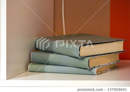 Hard cover books on shelf 137008041