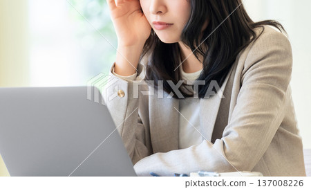 A woman/businesswoman worried while using a computer 137008226