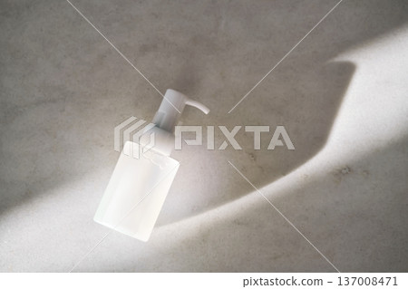 Skincare pump bottle on marble receiving sunlight 137008471