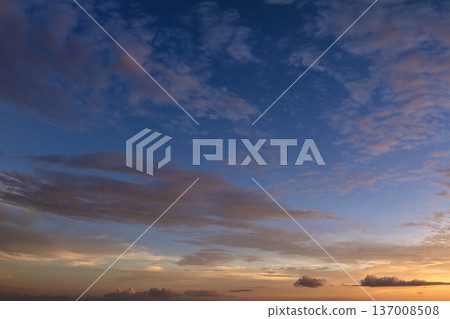 Bright sunset with setting sun behind vivid orange and yellow clouds 137008508