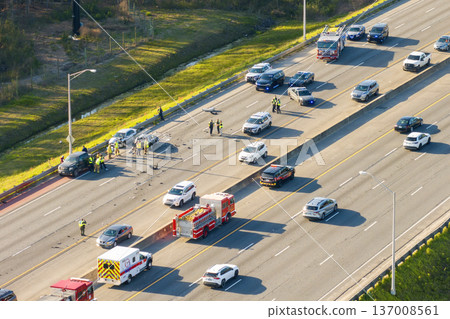 First responders at car accident site in Florida. Emergency services personnel helping victims of car crash on freeway in USA. 137008561