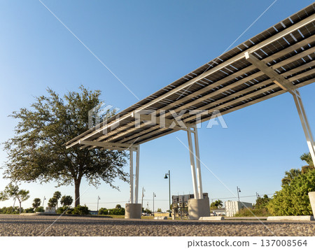 Photovoltaic solar panels over car parking lot for generation of renewable energy. Sustainable power production integrated in urban infrastructure. 137008564