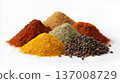 Variety of ground spices and whole peppercorns displayed in mounds on white background, vibrant cooking ingredients. 137008729