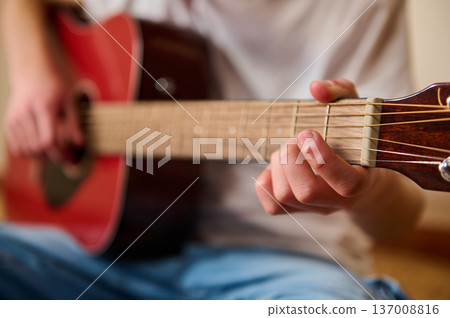 Young Person Playing Acoustic Guitar Close-Up Showing Fingers on Fretboard Young Person Playing Acoustic Guitar Close-Up Showing Fingers on Fretboard 137008816
