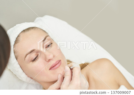 Caucasian female adult receiving cosmetic treatment at spa for skin rejuvenation and relaxation 137009007